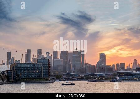 London, Newham, Royal Victoria Docks, skyline of Docklands financial district, O2 arena, commercial buildings, sunset Stock Photo