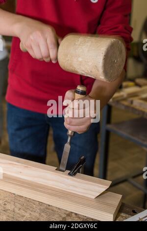 Carpenter Works In Workshop With Wooden Hammer And Chisel - Craftsman Stock Photo