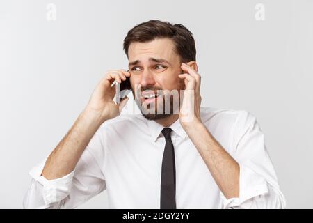 Angry and serious businessman talking on the phone over gray background Stock Photo