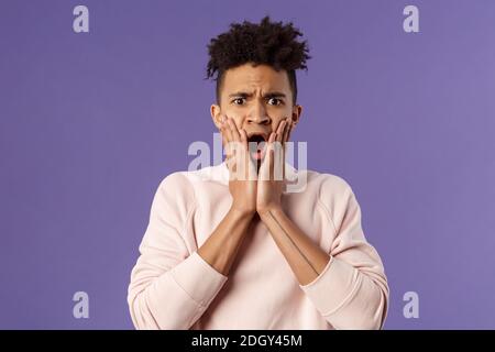 Oh gosh thats terrible. Portrait of shocked, speechless and worried young man express compassion finding out friend got in troub Stock Photo