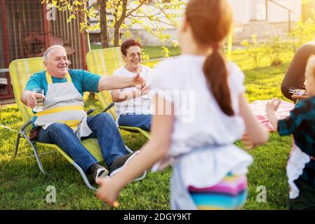 Elderly couple is spreading their arms and waiting for their grandchildren to hug them. Stock Photo