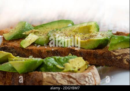 Avocado toast, sandwich with avocado, salt pepper and vinegar. close up. Stock Photo