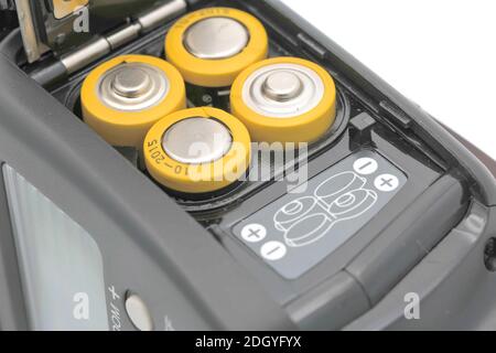 Four yellow rechargeable batteries in cobra camera flash, close up Stock Photo