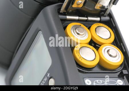 Four yellow rechargeable batteries in cobra camera flash, close up Stock Photo
