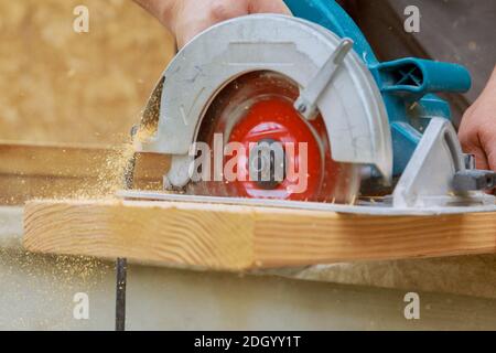 Cutting wood using an electrical chain saw professional tools Stock Photo