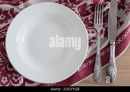 A white empty plate on a linen napkin Stock Photo