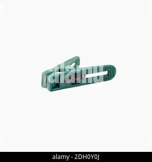 Green old plastic clothespin isolated on a white background. Close up Stock Photo