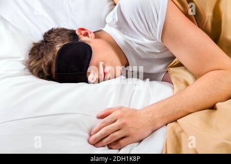Tired Young Man sleep in the Bed at the Home Stock Photo