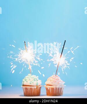 Two cupcakes decorated with sparklers, copy space Stock Photo