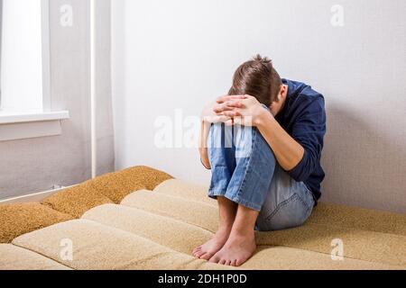 Sad Young Man on the Couch in the Room Stock Photo