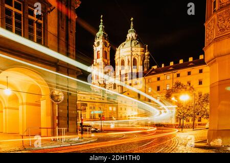 Night view of St. Nicolas Church, Prague, Czech republic. Long exposure city lights.Motion speed scene.Traffic trails in town.City street at night.Tra Stock Photo