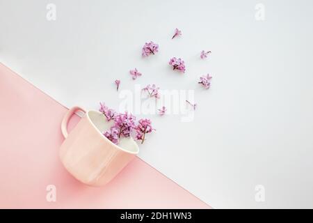 Layout made of pink coffee cup with smal lilac flowers. Minimalist creative composition Stock Photo