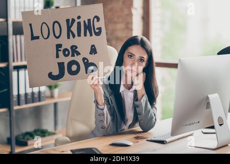 Photo of sad frustrated upset girl marketer financier agent sit desk hold cardboard text look for job have dismissed from company crisis recession Stock Photo