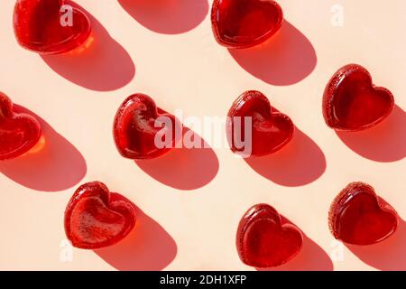 Small heart shaped red jelly candies with hard shadows. Valentine's day composition Stock Photo
