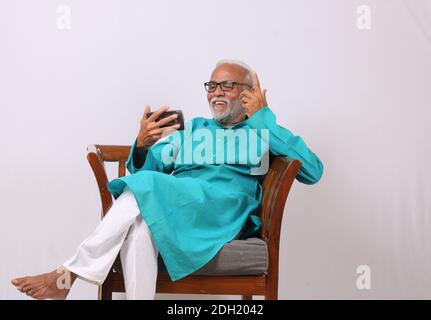 Cool bearded indian old man using mobile phone Stock Photo