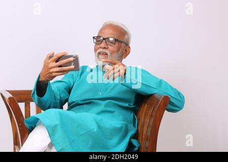 Cool bearded indian old man using mobile phone Stock Photo