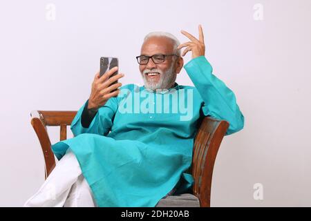 Cool bearded indian old man using mobile phone Stock Photo