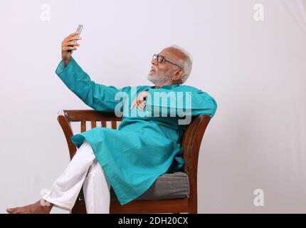 Cool bearded indian old man using mobile phone Stock Photo