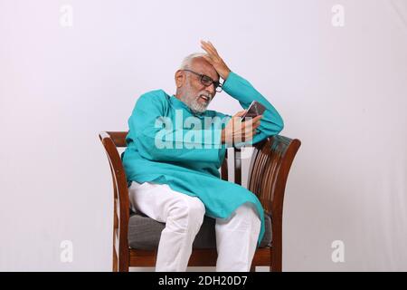 Cool bearded indian old man using mobile phone Stock Photo