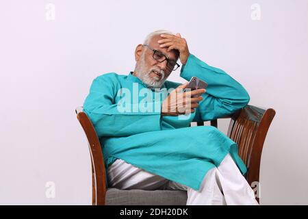 Cool bearded indian old man using mobile phone Stock Photo