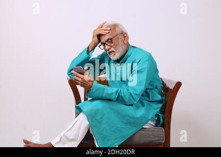 Cool bearded indian old man using mobile phone Stock Photo