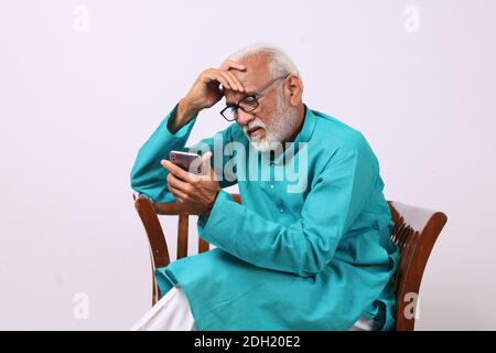 Cool bearded indian old man using mobile phone Stock Photo