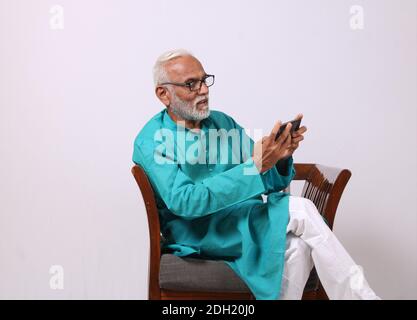 Cool bearded indian old man using mobile phone Stock Photo