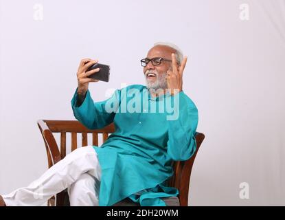Cool bearded indian old man using mobile phone Stock Photo