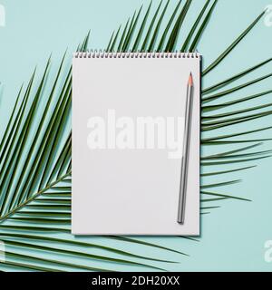 Blank paper notebook and tropical leaf Stock Photo