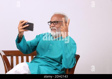 Cool bearded indian old man using mobile phone Stock Photo