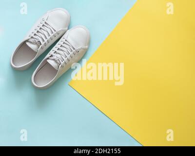 White sneakers on blue and yellow, copy space, top view Stock Photo