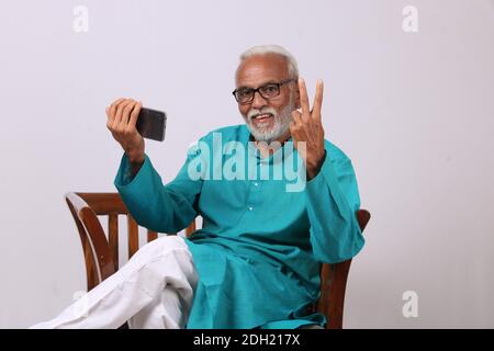Cool bearded indian old man using mobile phone Stock Photo