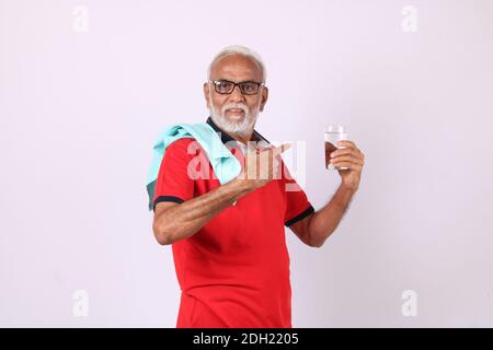 senior indian man drinking fresh water while or after weight training or gym Stock Photo