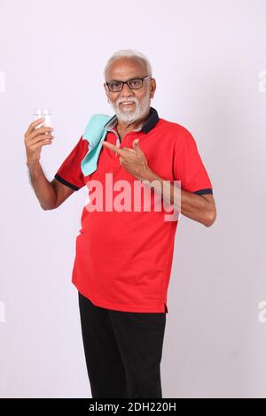 senior indian man drinking fresh water while or after weight training or gym Stock Photo