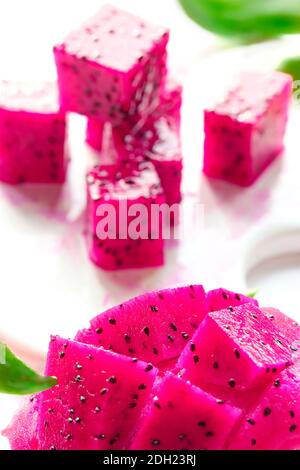 Pink dragon fruit, pitaya or pitahaya cut in cubes on cutting board. Trendy superfood. Stock Photo