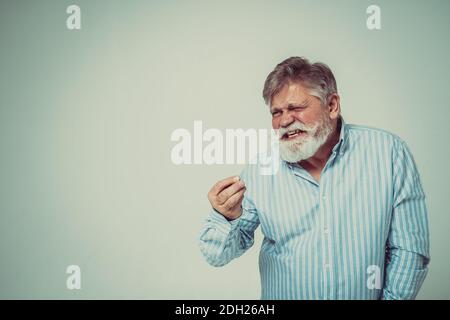 Funny senior man posing in a  photoshooting. Happy hipster doing funny expressions. Concept about people and lifestyle. Stock Photo