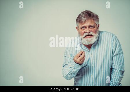 Funny senior man posing in a  photoshooting. Happy hipster doing funny expressions. Concept about people and lifestyle. Stock Photo