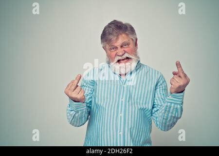 Funny senior man posing in a  photoshooting. Happy hipster doing funny expressions. Concept about people and lifestyle. Stock Photo