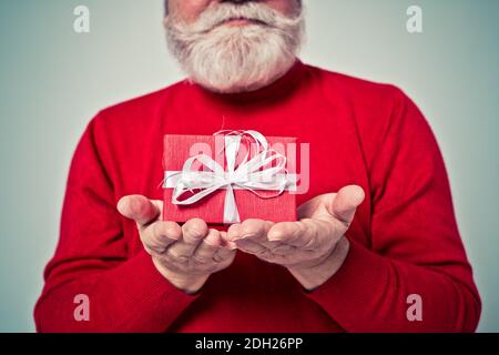 Funny senior man posing as santa claus in a  photoshooting. Happy hipster doing funny expressions. Concept about people and christmas Stock Photo
