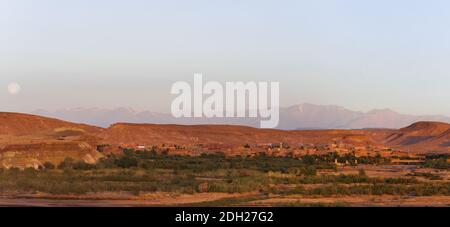 Ait Ben Haddou on the horizon the Atlas Mountains with full moon in the south of Morocco, Africa. Stock Photo