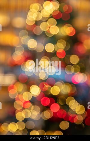 Christmas lights colorful bokeh background. Holiday festive celebration event decoration. Xmas tree in a store display, defocused blur view behind the Stock Photo