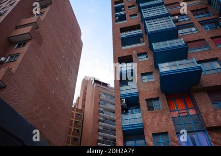 Residential buildings from low angle view in downtown of Cordoba city. High rise apartment buildings brick with blue balcony. Argentina Stock Photo