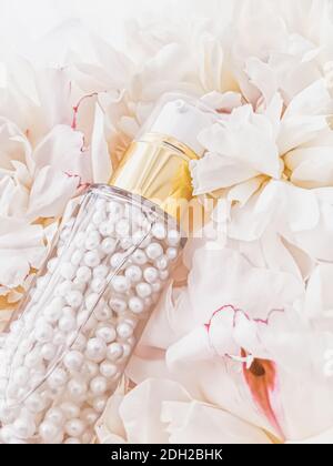 Luxurious cosmetic bottle as antiaging skincare product on background of flowers, blank label packaging for body care branding Stock Photo