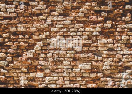 Old brick wall texture. Weathered wall surface. Grungy orange brickwall. Red stonewall background. Shabby building facade Italia Stock Photo