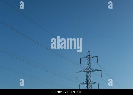 A pylon carrying power cables, framed against a blue sky, Saddleworth, Oldham,UK Stock Photo