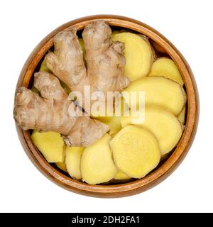 Fresh ginger roots, whole and sliced, in a wooden bowl. Rhizomes of Zingiber officinale, used as a fragrant spice and as a folk medicine.