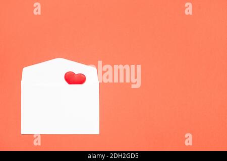 Opened white envelope and heart on red background with copy space. Stock Photo