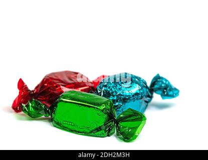 Candies wrapped in colorful foil against a white background Stock Photo