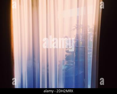 Curtains on window at sunset Stock Photo