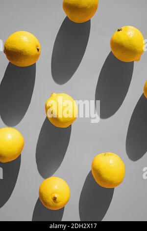 Flat lay composition with lemons on grey background in natural sunlight with hard shadows, top view. Illuminating and Ultimate Gray colors of the year Stock Photo